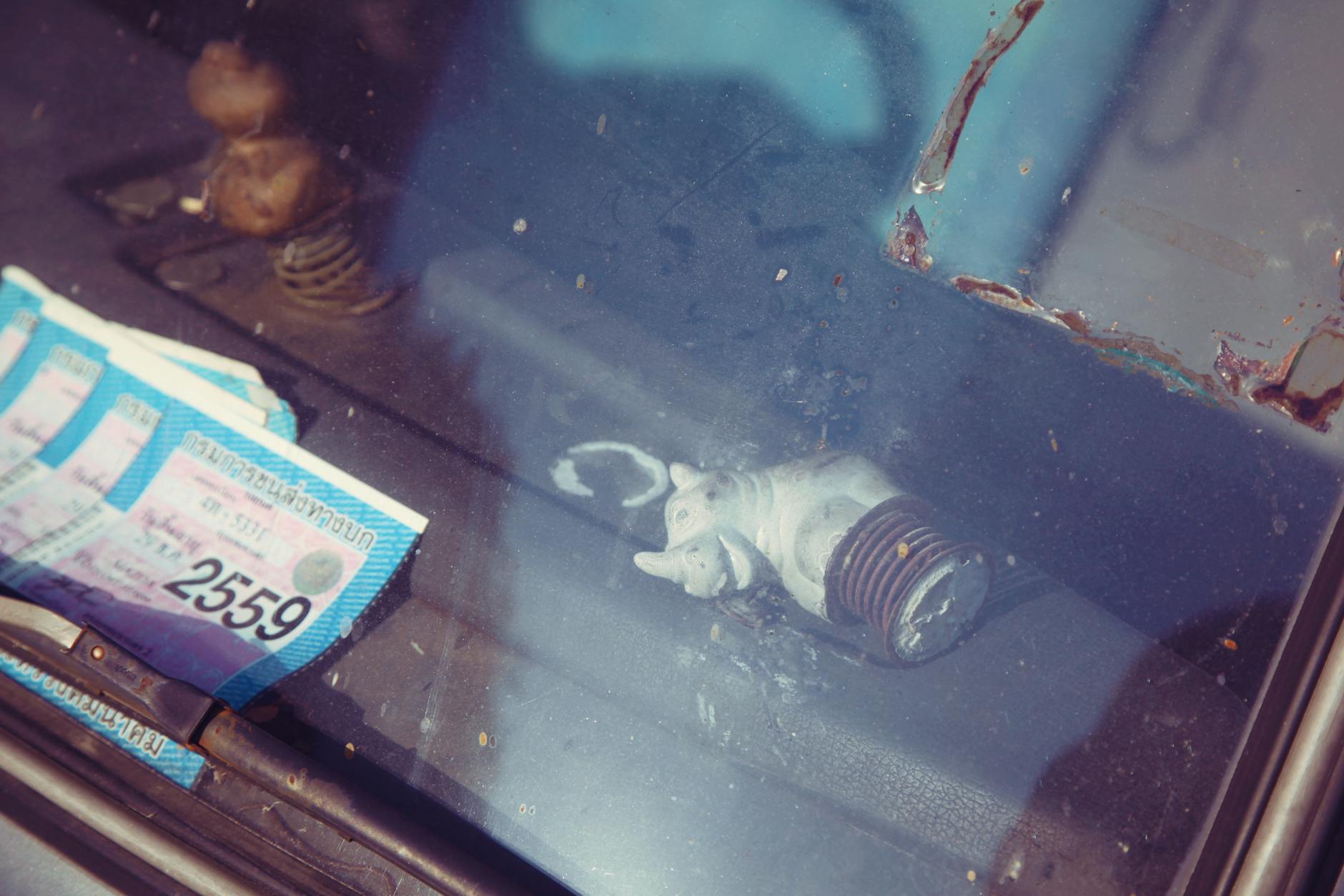 Pozwolenie na budowę wygasło: kiedy to się dzieje i jak uratować inwestycję? Dokumenty pozwolenia na budowę i figurka nosorożca za szybą auta