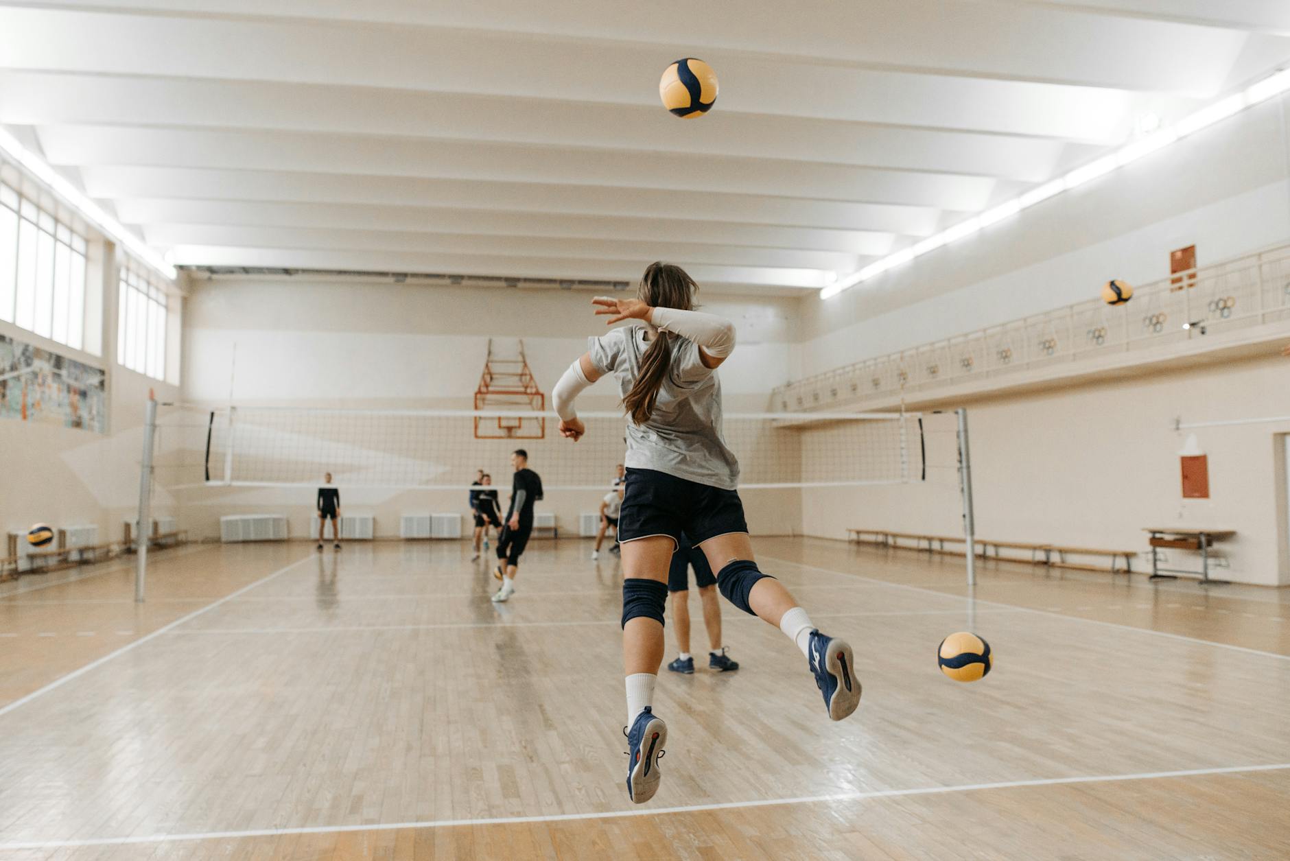 Amatorski mecz siatkówki w hali sportowej podczas dynamicznej akcji